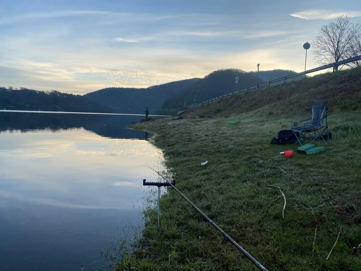 Angelplatz am Ufer des Rursees im ruhigen Morgenlicht, Ruten und Ausrüstung liegen bereit