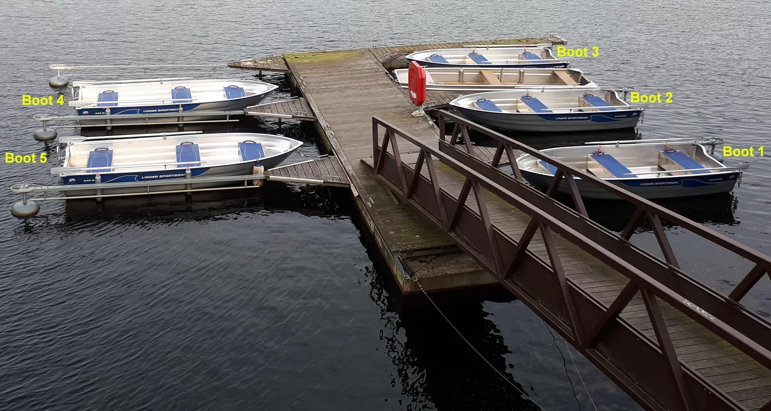 Fischerei-Pächtergemeinschaft Rursee e.V. - Nachhaltige Sportfischerei und Umweltschutz - Eine Draufsicht auf fünf kleine Aluminium-Motorboote mit den Bezeichnungen Boot 1 bis Boot 5, die um einen hölzernen Schwimmsteg mit Brückenrampe angedockt sind.